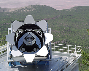 A photo of the SDSS's telescope in front of 
    the mountains in southern New Mexico
